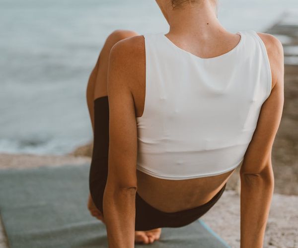 Person stretching gently outdoors during a calm morning.